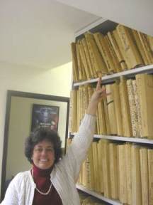 Music Restorer Kathleen Mayne at Warner Brothers Music Library, pointing to scores from THEM